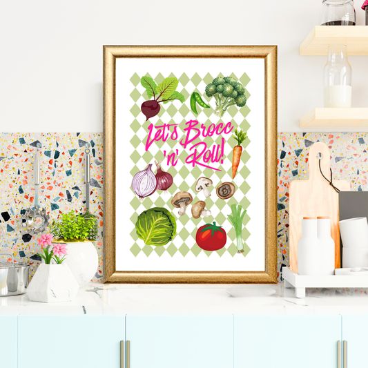 Framed kitchen art print with green diamond check background featuring illustrated vegetables including broccoli, beetroot, carrots, onions, mushrooms, cabbage, tomato, peas, and leek, with bright pink text reading “Let’s Brocc ’n’ Roll!” in situ