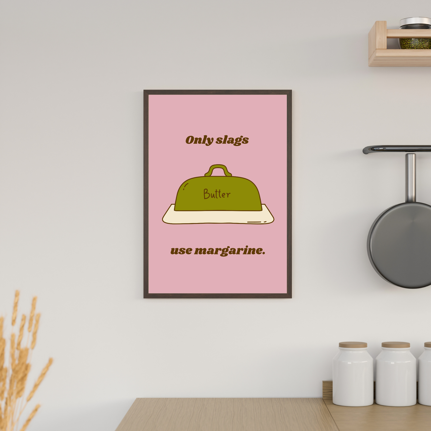 Framed poster with a pink background and text about margarine in a kitchen setting.