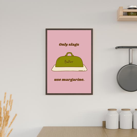 Framed poster with a pink background and text about margarine in a kitchen setting.