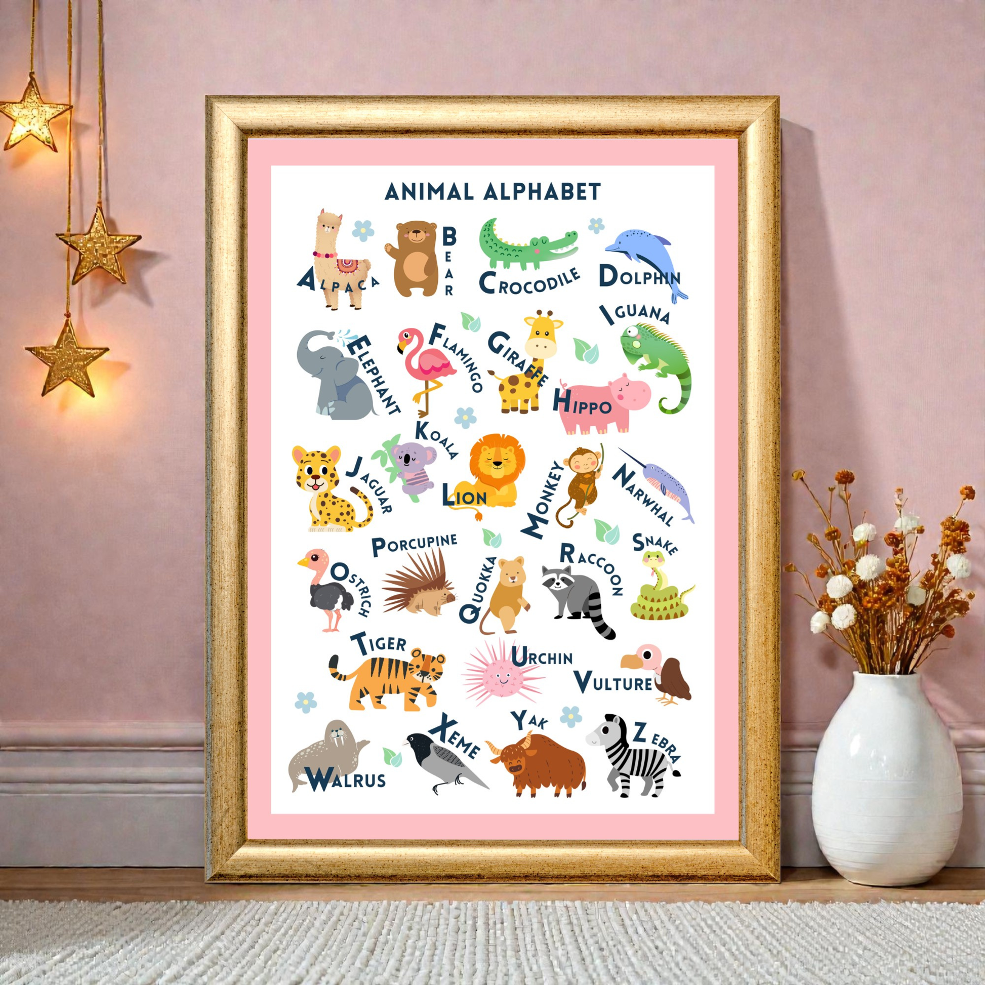 Framed animal alphabet poster on a pink wall with decorative elements.