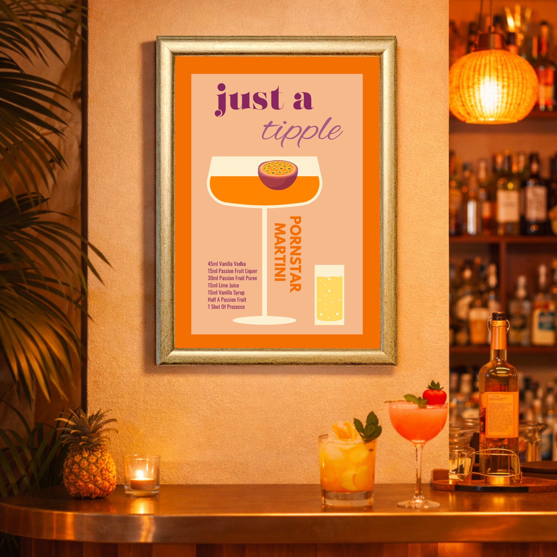 Framed cocktail poster on a warmly lit bar wall reading “just a tipple – Pornstar Martini,” featuring a stylized illustration of an orange martini glass with a halved passion fruit on top and a small prosecco shot beside it. The recipe text is printed below. On the bar counter beneath are a pineapple, a lit candle, two colorful cocktails, and liquor bottles in the background.