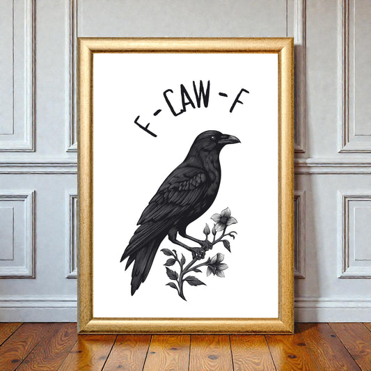 Gold-framed black-and-white raven illustration with floral details and the text “F-Claw-F,” leaning against a panelled wall on a wooden floor in a styled interior setting.