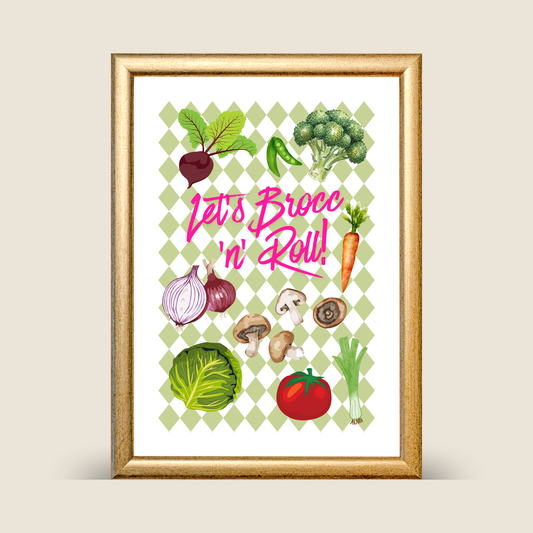 Framed kitchen art print with green diamond check background featuring illustrated vegetables including broccoli, beetroot, carrots, onions, mushrooms, cabbage, tomato, peas, and leek, with bright pink text reading “Let’s Brocc ’n’ Roll!”