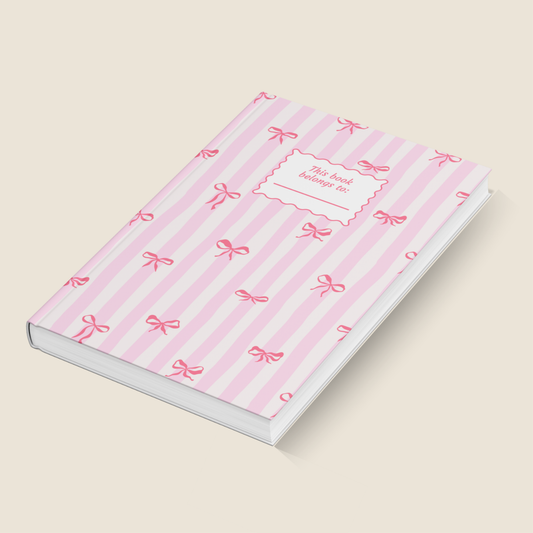 Notebook with pink striped cover and bow pattern on a beige background