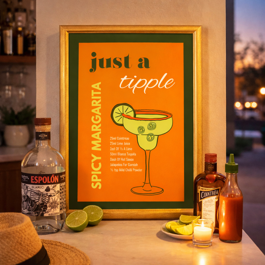 Framed poster with 'Just a Tipple Spicy Margarita' design on a bar counter with alcohol bottles and limes.