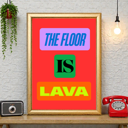 Framed “The Floor Is Lava” typography art print with bold colourful text on a red background, styled on a shelf with plants, a vintage camera, and a red telephone.