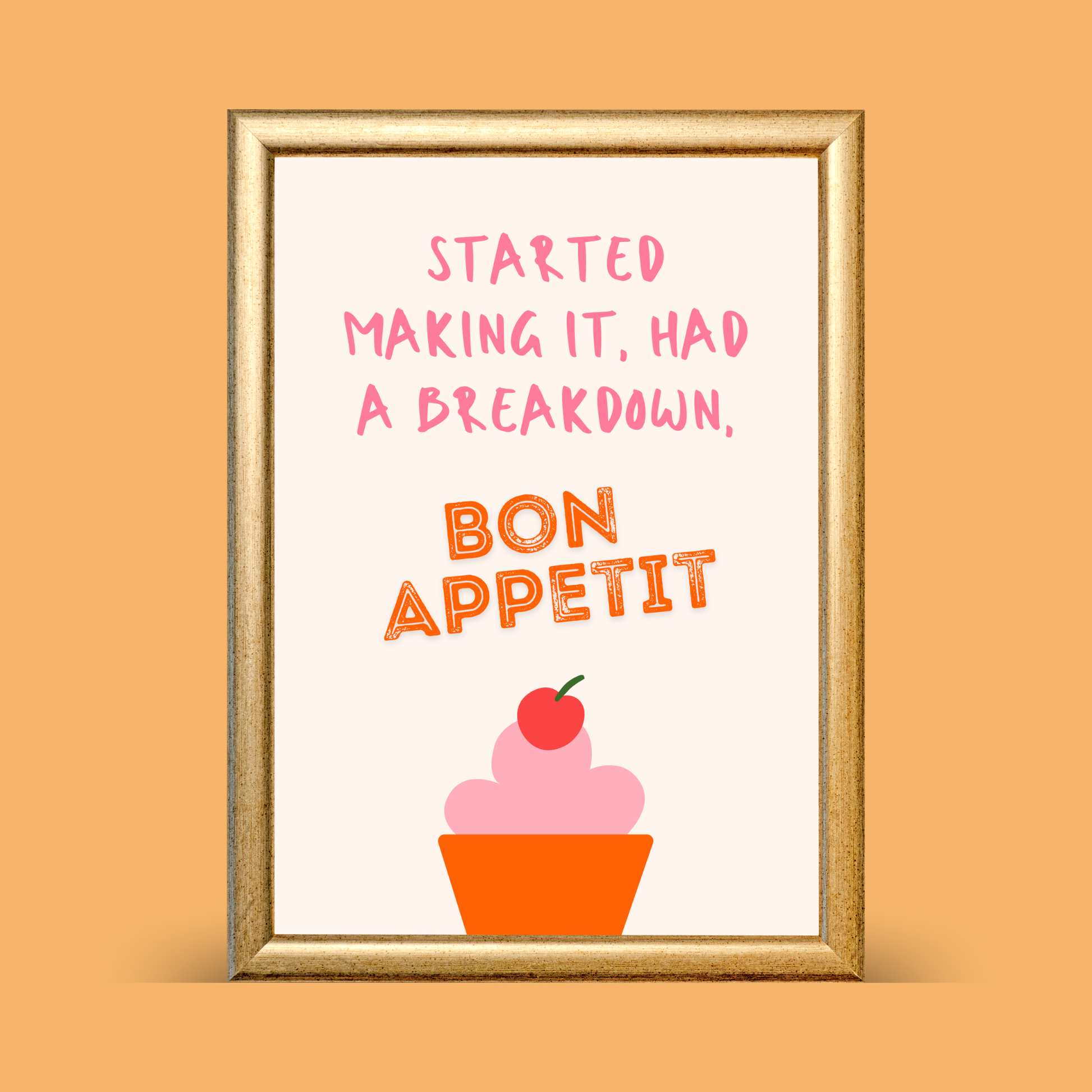 Framed artwork with text 'Started making it, had a breakdown, Bon Appetit' and a cupcake illustration on an orange background.
