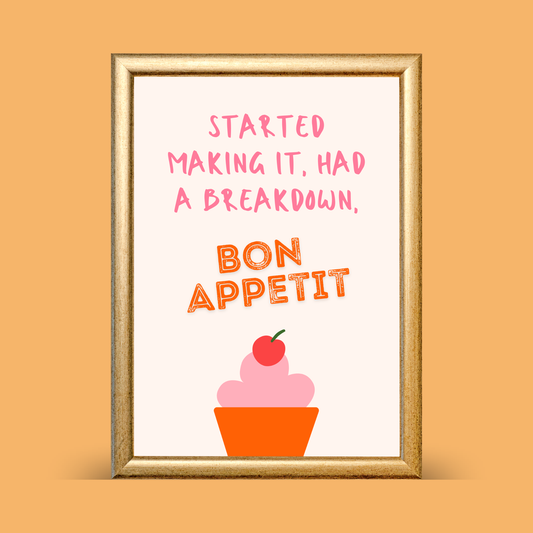 Framed artwork with text 'Started making it, had a breakdown, Bon Appetit' and a cupcake illustration on an orange background.