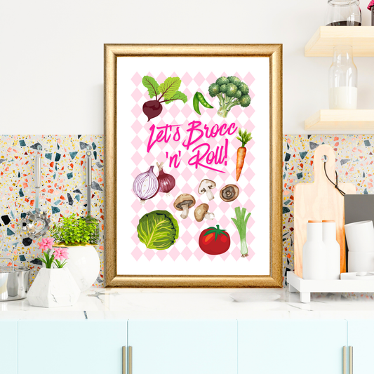 Framed artwork with vegetables and 'Let's Brocc n' Roll!' text on a kitchen wall.