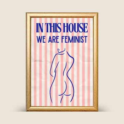 Framed poster with 'In this house we are feminist' text and a silhouette of a woman on a striped background.