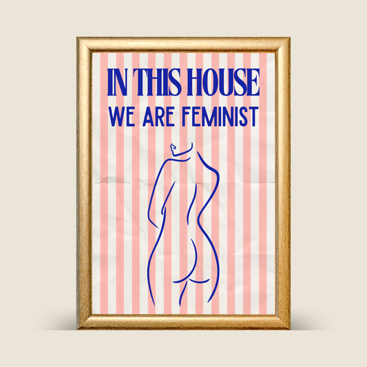 Framed poster with 'In this house we are feminist' text and a silhouette of a woman on a striped background.